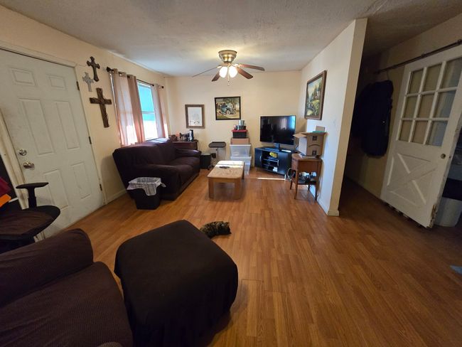 Living room featuring wood finished floors, a ceiling fan, and a textured ceiling | Image 17