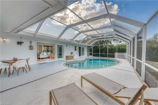 Outdoor pool featuring glass enclosure and a patio | Image 4