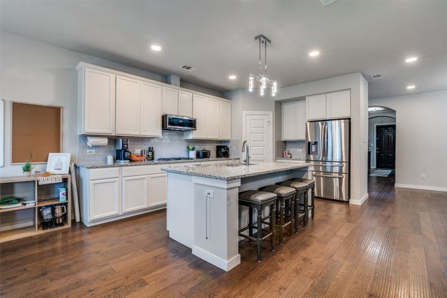 Kitchen with appliances with stainless steel finishes, tasteful backsplash, an island with sink, white cabinetry, and recessed lighting | Image 12
