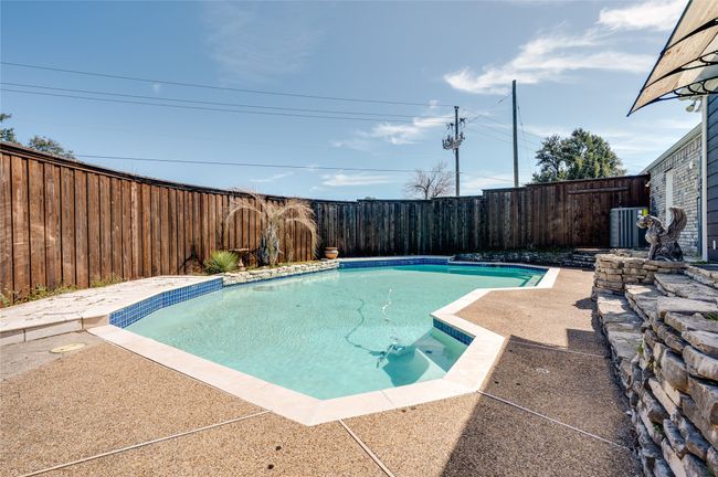 View of swimming pool with a fenced in pool, a fenced backyard, and a patio | Image 26