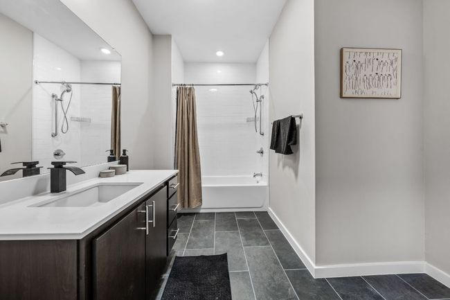 Bathroom featuring vanity, tile patterned floors, baseboards, and shower / bath combo with shower curtain | Image 20