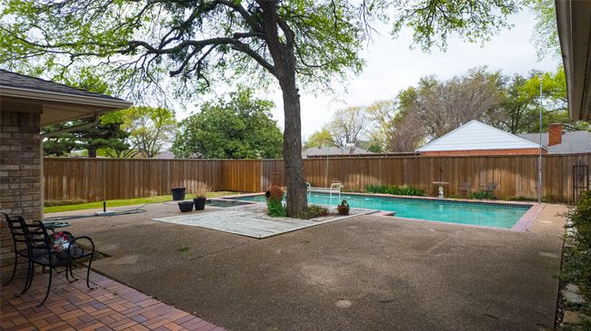 View of swimming pool with a fenced in pool, a patio area, and a fenced backyard | Image 5