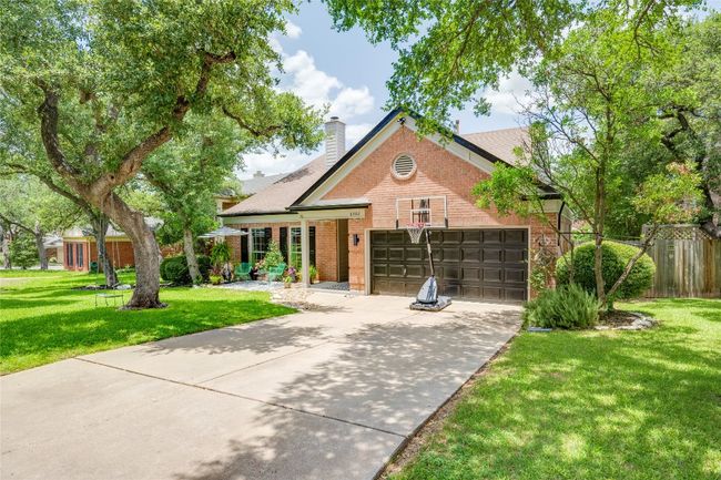 View of front facade with brick siding, driveway, an attached garage, and a chimney | Image 5