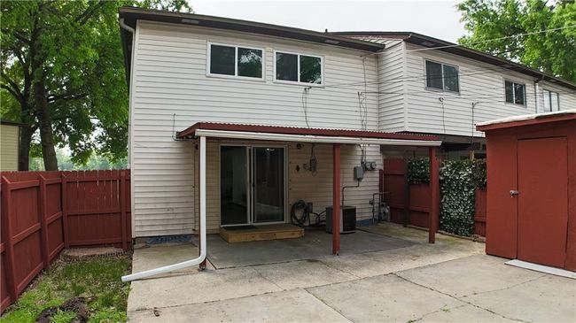 Back of property with a patio area, a fenced backyard, and a storage shed | Image 25