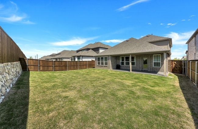 Back of property featuring a shingled roof, a fenced backyard, a yard, a patio, and brick siding | Image 27