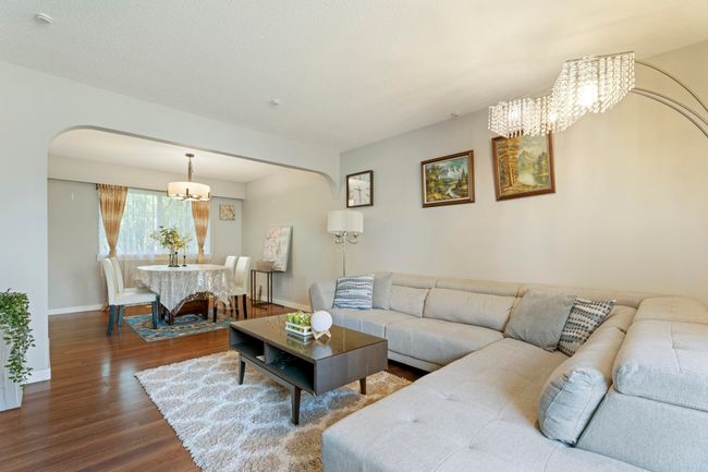 Living room featuring baseboards, arched walkways, a chandelier, and dark wood finished floors | Image 10