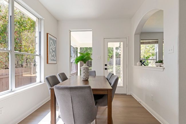 Dining space featuring arched walkways and wood finished floors | Image 9