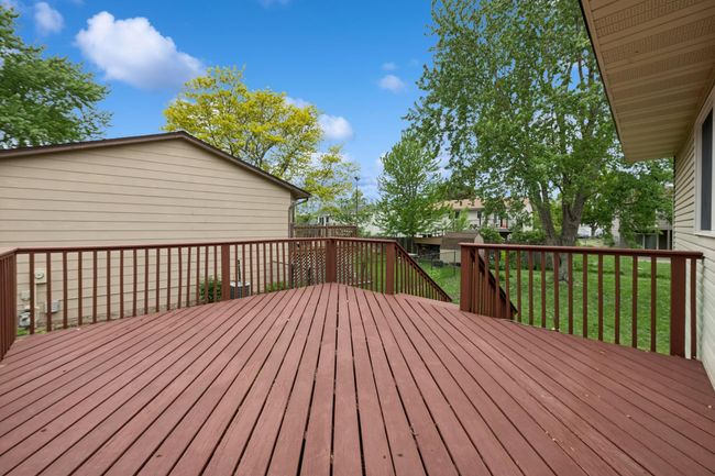 The large deck features stairs so you can directly access the usable, flat backyard area. | Image 7