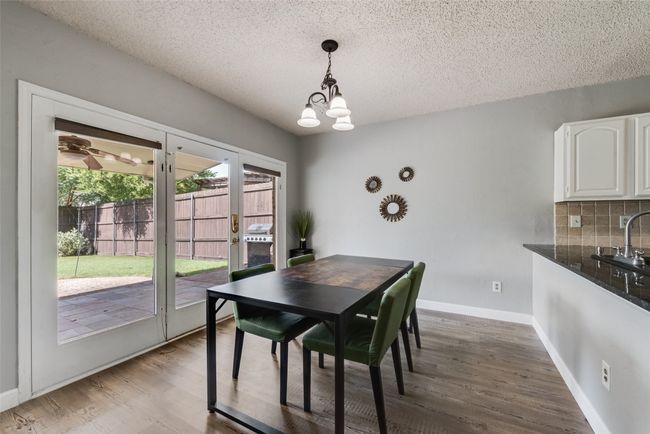 Dining space featuring a chandelier, a textured ceiling, and wood finished floors | Image 13