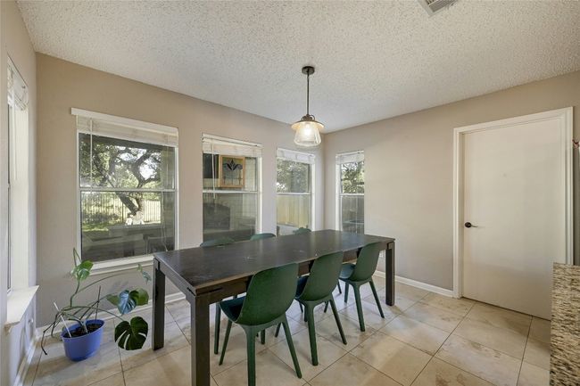 Dining room with healthy amount of natural light, a textured ceiling, and light tile patterned floors | Image 15