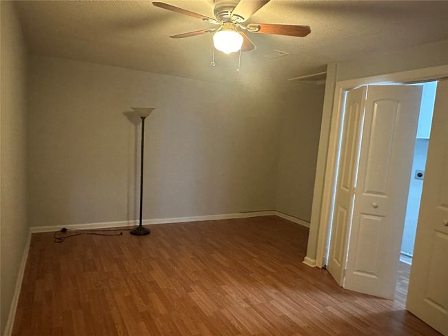 Unfurnished room featuring a textured ceiling, baseboards, ceiling fan, and wood finished floors | Image 6