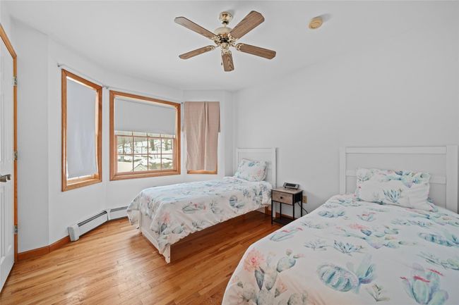 Bedroom featuring baseboard heating, a ceiling fan, and light wood-type flooring | Image 30
