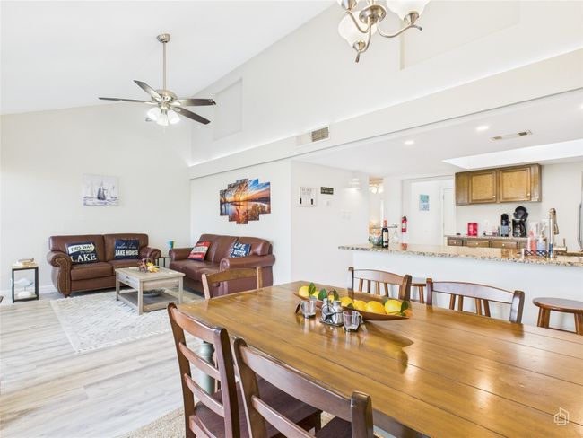 Dining space with high vaulted ceiling, light wood-type flooring. | Image 9