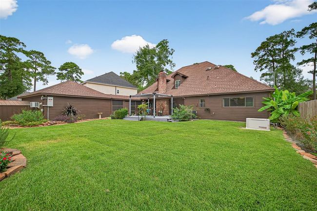 From the backyard, the home’s rear profile is as charming as its front—bordered by vibrant garden beds and a sense of privacy. | Image 45