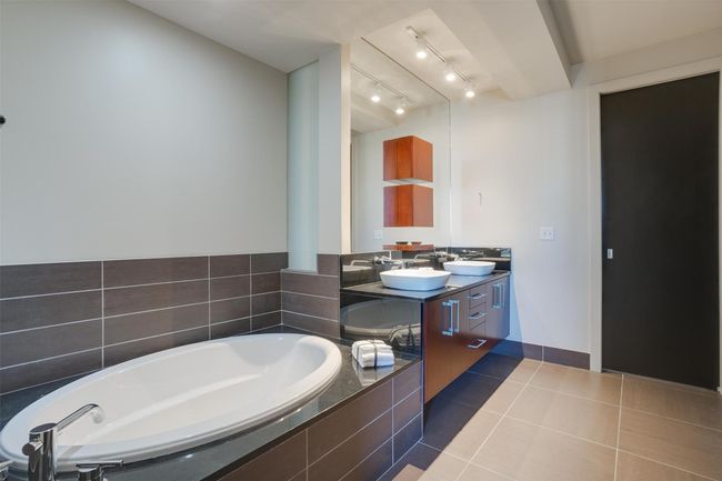 Bathroom featuring double vanity, a bath, and tile patterned floors | Image 33