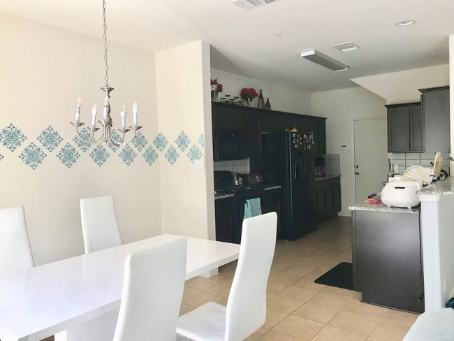 Dining area featuring light tile patterned floors, visible vents, and a chandelier | Image 6