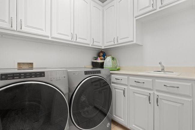 Laundry area featuring washer and dryer, cabinet space, and sink | Image 18