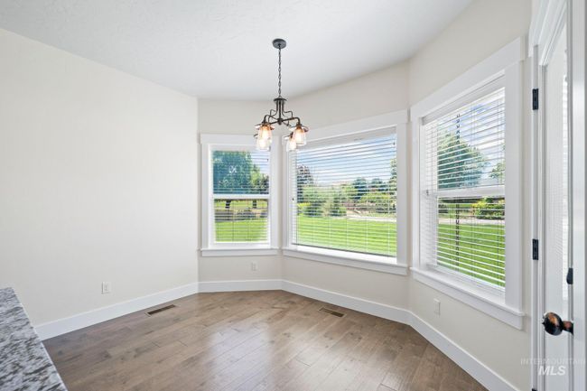 Unfurnished dining area featuring a chandelier and hardwood / wood-style flooring | Image 12