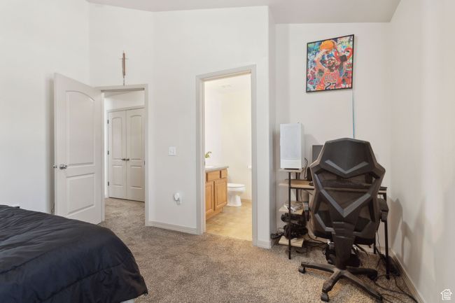 Bedroom featuring light colored carpet, baseboards, and ensuite bathroom | Image 20