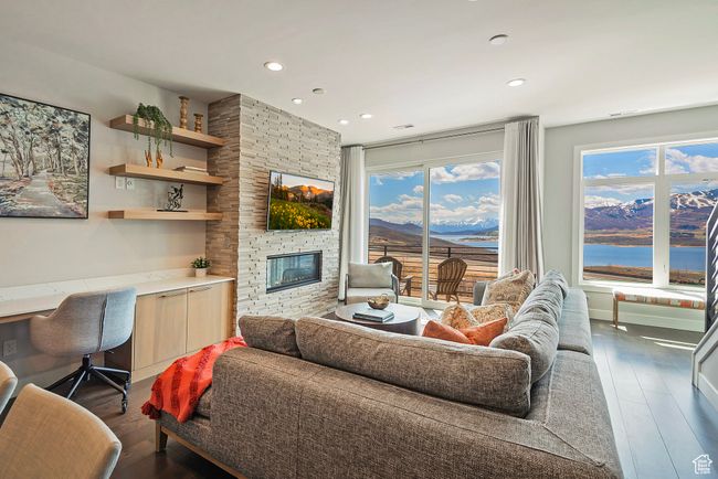Living room with built in study area, recessed lighting, dark wood-type flooring, and a fireplace | Image 5