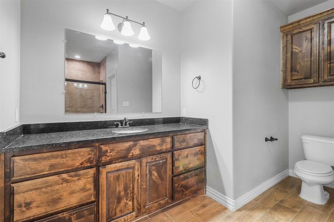 Full bathroom featuring vanity, a tile shower, and wood finish floors | Image 10