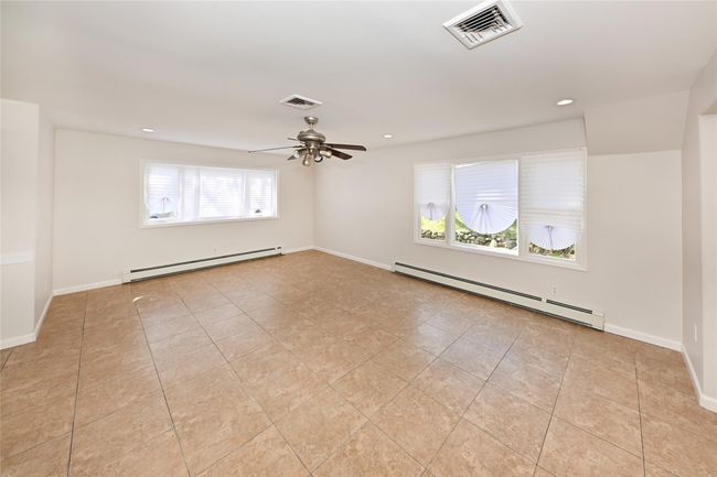 Spare room featuring visible vents, ceiling fan, and a baseboard radiator | Image 5
