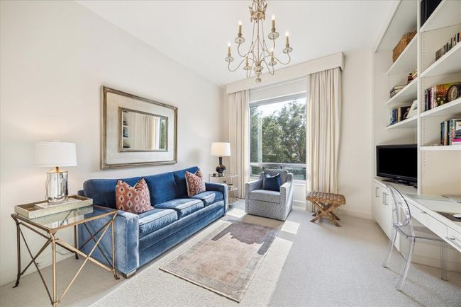 The second bedroom has custom built in shelving, drawers and cabinets. There is even a roll out cabinet for a printer. The sofa bed turns this into a comfortable space for guests and the tree lined views continue to surround the condo. | Image 24