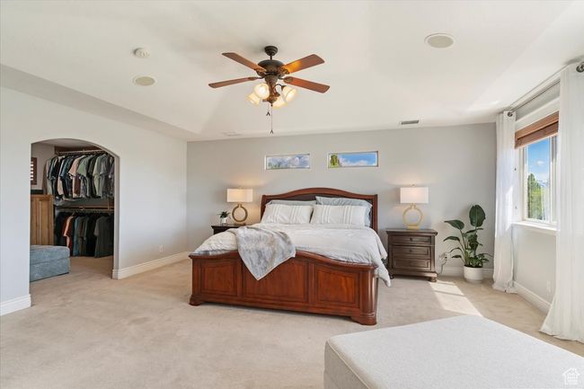 Bedroom with baseboards, visible vents, a ceiling fan, and light colored carpet | Image 32