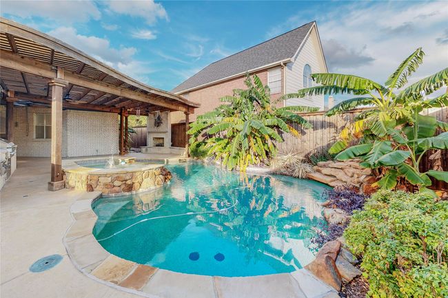 View of swimming pool with a pergola, a fenced backyard, a pool with connected hot tub, and a patio | Image 39