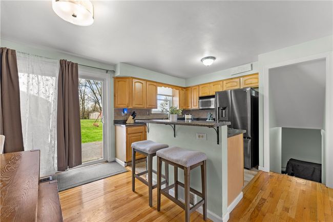 This kitchen features a center island with a breakfast area, all appliances are included, and it has beautiful countertops! | Image 7