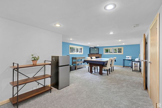 Recreation room featuring carpet floors, recessed lighting, a fireplace, and baseboards | Image 20