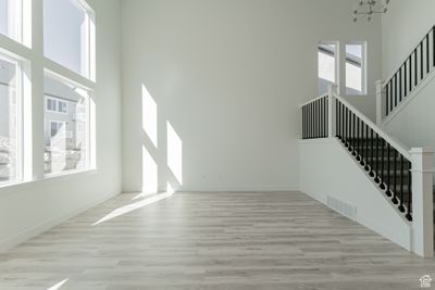 Interior space with a chandelier, a high ceiling, and light hardwood / wood-style floors | Image 2