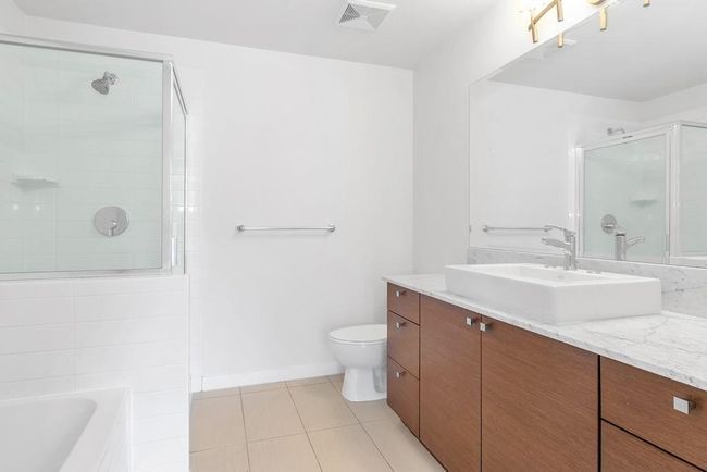 Bathroom with tiled shower, vanity, tile patterned floors, and a bath | Image 15