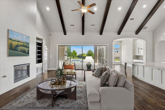 Virtually Staged living room featuring dark wood-style floors, ceiling fan, surround sound, plenty of natural light, and recessed lighting | Image 7