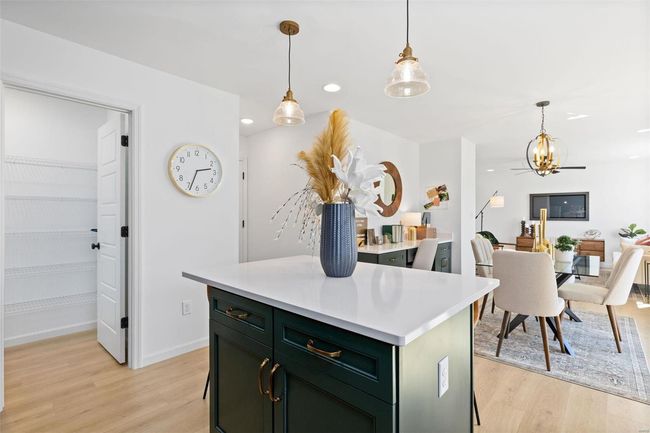 Kitchen with light wood-type flooring, a center island, and decorative light fixtures | Image 13