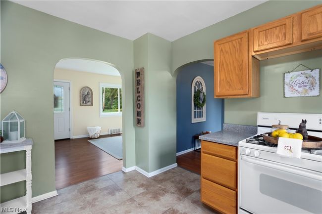 Kitchen featuring white gas range, hardwood floors, and brown cabinets | Image 9