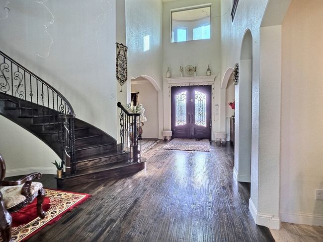 Foyer with arched walkways, stairs, a towering ceiling, wood finished floors, and baseboards | Image 18