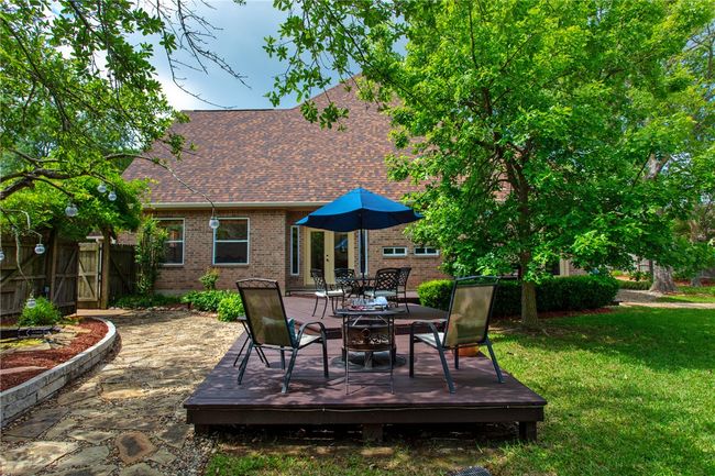 View of patio featuring a wooden deck, fence, and outdoor dining space | Image 29