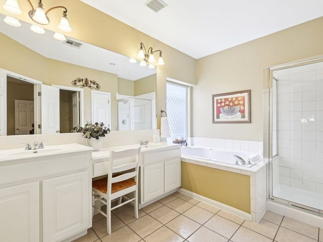 Bathroom featuring a stall shower, double vanity, a bath, and tile patterned flooring | Image 18