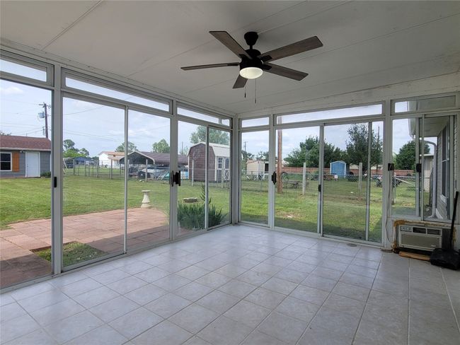 Sunroom enclosed with glass, sliding doors with a ceiling fan | Image 20
