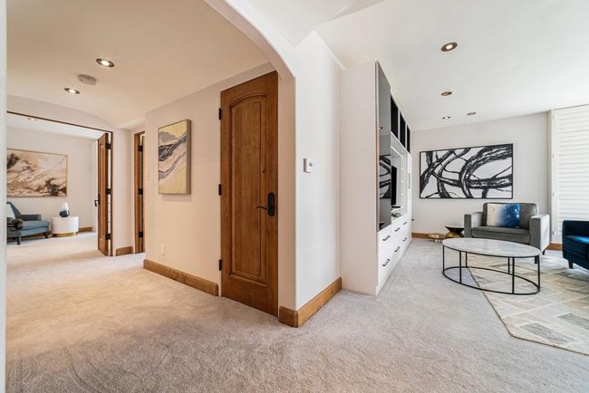View of arched and widened hallway and living room from entry area. | Image 13