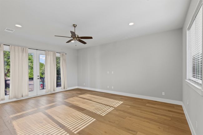 Empty room with plenty of natural light, hardwood / wood-style flooring, a ceiling fan, and recessed lighting | Image 8