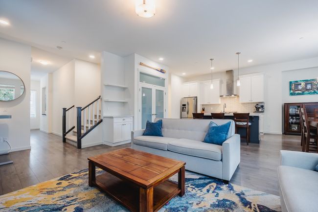 Living room featuring recessed lighting, wood finished floors, baseboards, and stairs | Image 6