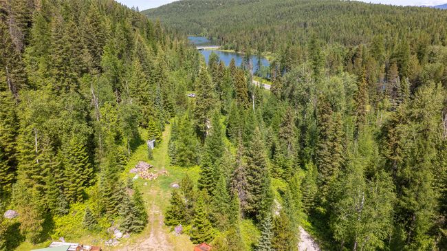 Drone / aerial view of a heavily wooded area and a water and mountain view | Image 64