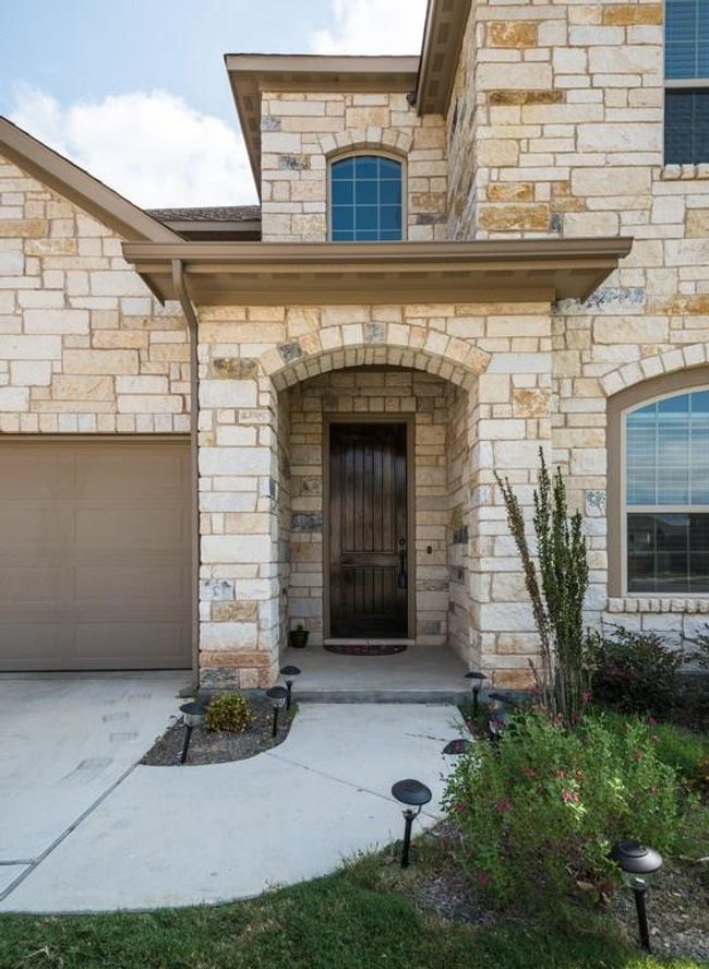 Property entrance with an attached garage and stone siding | Image 4