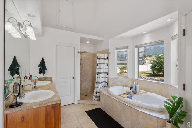 Bathroom with a stall shower, a garden tub, double vanity, tile patterned flooring, and recessed lighting | Image 15