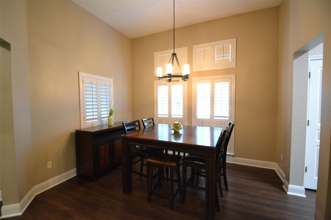Dining area featuring a chandelier and dark wood-style flooring | Image 11