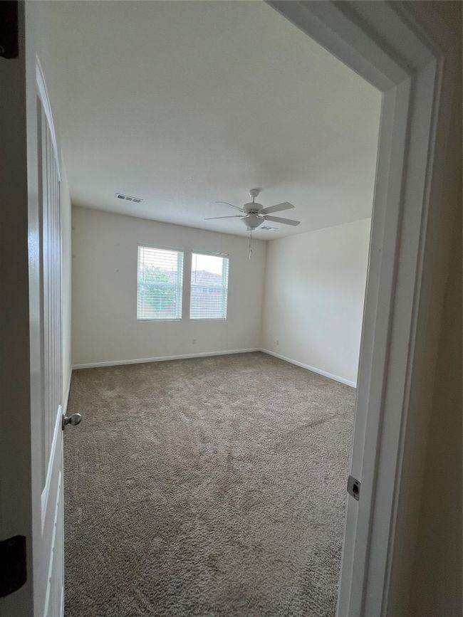 First of 2 Carpeted spare bedrooms featuring ceiling fan and spacious double sliding door closet. | Image 14