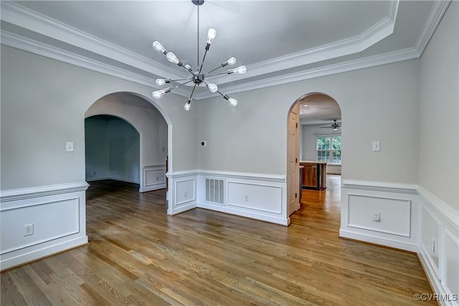 Dining room with wainscoting, crown molding & archway details. | Image 7