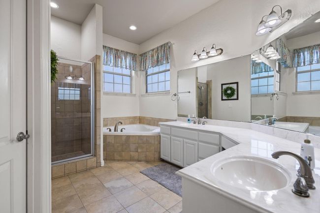 Double sinks, jetted-tub, walk-in shower, large walk in closet with custom built-ins. | Image 21
